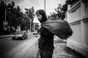 un hombre asiático no tiene hogar en la calle lateral, un extraño tiene que vivir solo en la calle porque no tiene familia. foto