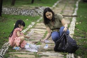 Asian mother and daughter help garbage collection charity environment. photo