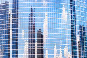 The reflection of cloud and buildings in the windows of modern office building photo