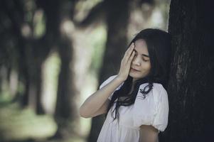 hermosa chica asiática se siente sola en el bosque, concepto de mujer triste, gente de Tailandia, señora tristeza por el amor de su novio, se siente con el corazón roto foto