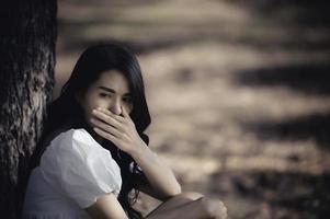 hermosa chica asiática se siente sola en el bosque, concepto de mujer triste, gente de Tailandia, señora tristeza por el amor de su novio, se siente con el corazón roto foto