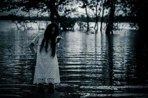 retrato de asiático mujer hacer arriba fantasma cara a el pantano, terror en agua escena, miedo a río, víspera de todos los santos cartel,tailandia personas foto