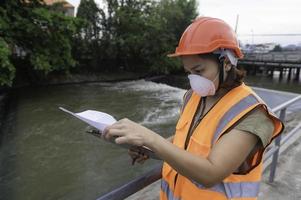 un avanzado eléctrico ingeniero inspecciona el eléctrico sistema de el abastecimiento de agua,mantenimiento técnicos para el controlar sistema de el aguas residuales tratamiento sistema foto