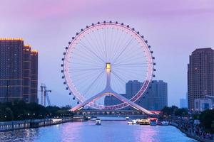 TIANJIN, CHINA - JUL 04, 2016-Tianjin is a metropolis in northern coastal China, tall giant Ferris wheel built above the Yongle Bridge, over the Hai River in Tianjin. JULY 04, 2016 photo