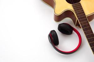 Acoustic guitar on a white background and the headphones are placed on the side. Concept of love, leisure and music. photo