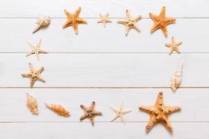 Flat lay of various seashell and starfish on white wooden table, top view. Copy space background, summer concept photo