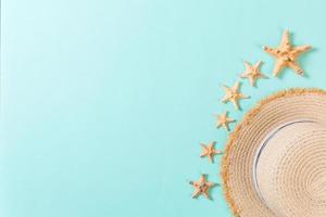 Beach hat with seashells on brown blue table. summer background concept with copy space top view photo