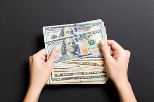 Top view of different dollar banknotes in female hands on colorful background. Business and financial concept photo