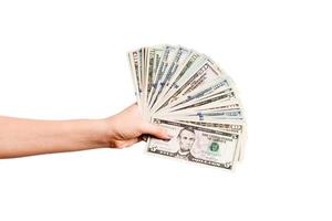 Top view of female hand giving a fan of dollar bills on isolated background. Profit and luxury concept photo