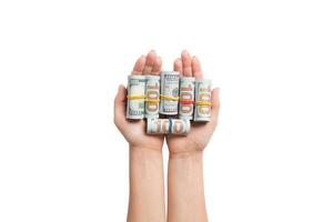 Top view of rolled up in tubes dollar bills in female palms on white isolated background. Poverty and debt concept photo