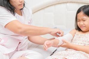 Mother first aid child patient's arm sprain photo