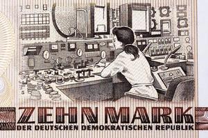 Female engineer sitting at a control console inside the Rheinsberg Nuclear Power Plant from East German money photo