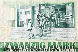 Several young children exiting a school from East German money photo