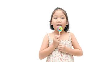 linda asiático niña comiendo caramelo aislado foto