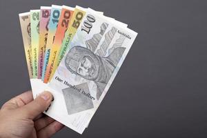 Old Australian money in the hand on a gray background photo