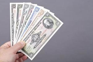 Old Mexican money in the hand on a gray background photo