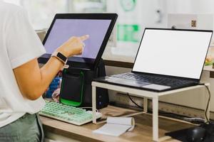 mujer mano conmovedor computadora pantalla a cajero encimera. foto