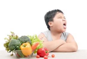 boy with expression of disgust against vegetables photo
