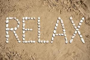 Relax - Word Made with Stones on Sand photo