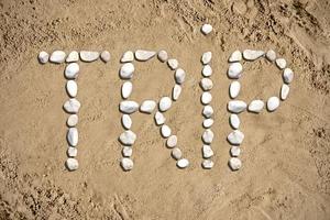 Trip - Word Made with Stones on Sand photo