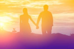 Young couple in love at sunset on the Mountain photo