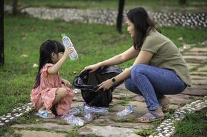Asian mother and daughter help garbage collection charity environment. photo