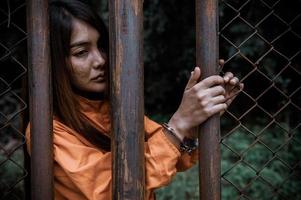 preso en concepto de túnica naranja, retrato de mujer asiática en uniformes de prisión sobre fondo blanco, foto