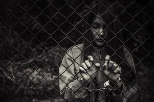 Portrait of women desperate to catch the iron prison,prisoner concept,thailand people,Hope to be free,If the violate the law would be arrested and jailed. photo