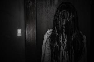 retrato de mujer asiática maquillada fantasma, escena de terror aterradora para el fondo, concepto de festival de halloween, afiche de películas fantasma, espíritu enojado en el apartamento foto