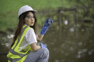 los ingenieros ambientales inspeccionan la calidad del agua, llevan el agua al laboratorio para su análisis, verifican el contenido de minerales en el agua y el suelo, verifican los contaminantes en las fuentes de agua. foto