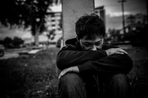 un hombre asiático no tiene hogar en la calle lateral, un extraño tiene que vivir solo en la calle porque no tiene familia. foto