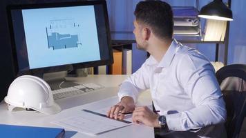 Young male designer sitting at desk and drawing on a house plan, interior design concept. Male interior designer working on a house plan, drawing and using ruler. video