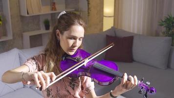 talentueux musicien femme en jouant violon dans vivant pièce à maison. réussi musicien femme en jouant violon à Accueil et souriant. video