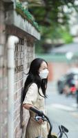 Guangzhou City, China, 2022 - One mask girl taking pictures on her city tourism photo