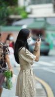 Guangzhou City, China, 2022 - One mask girl taking pictures on her city tourism photo