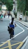 Guangzhou City, China, 2022 - One girl riding the bicycle through the street in the city photo