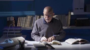 antiguo hombre leyendo un libro, investigador, historiador, alumno, profesor. de cerca antiguo hombre leyendo un libro. un hombre leyendo un libro es haciendo investigación, coleccionar información. video