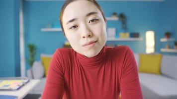 Asian woman thoughtfully looking around and at camera. Young Asian woman looks thoughtful and motionless towards the camera. video