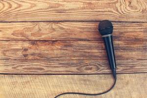 Microphone on wooden background. Toned image. photo