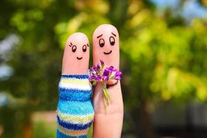 Finger art of a Happy couple. Man is giving flowers pregnant woman. photo