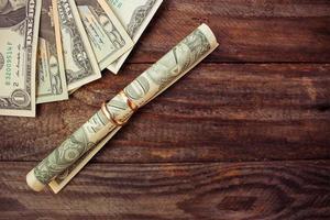 Wedding rings and dollars on the old wooden background. Toned image photo