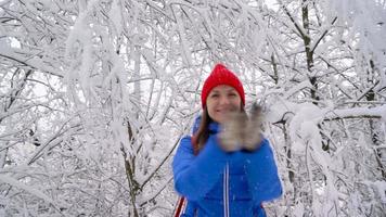 Lonely tourist girl walking on a winter snow-covered coniferous forest in the mountains. Frosty weather. Slow motion video