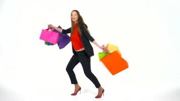 fêmea comprador segurando multicolorido compras bolsas em branco fundo dentro estúdio. vamos ir compras conceito video