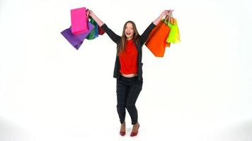 Female shopper holding multicolored shopping bags on white background in studio. Let's go shopping concept video