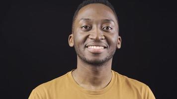 Close-up portrait of smiling friendly african young man. Friendly optimistic african young man looking at camera and smiling. video