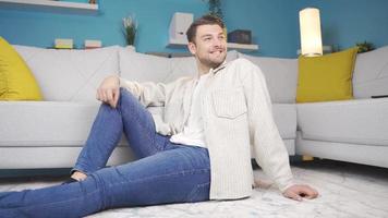 ung man ser runt om leende lyckligt, sedan framställning en positiv gest mot de kamera. Lycklig man leende och ser runt om och ser på kamera framställning positiv tecken. video
