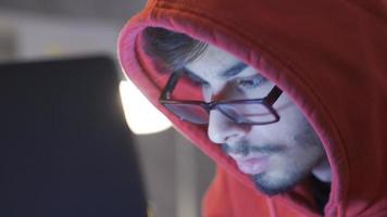 Close-up of young man working on laptop at night. Young man working on laptop at night. He is attentive and motivated. video