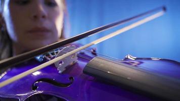 närbild av musiker spelar fiol på skede. närbild av kvinna spelar fiol på opera skede eller musik hall. video