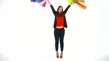 Female shopper holding multicolored shopping bags on white background in studio. Let's go shopping concept video