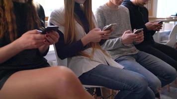 Group of people use mobile phones in a cafe instead of communicating with each other video